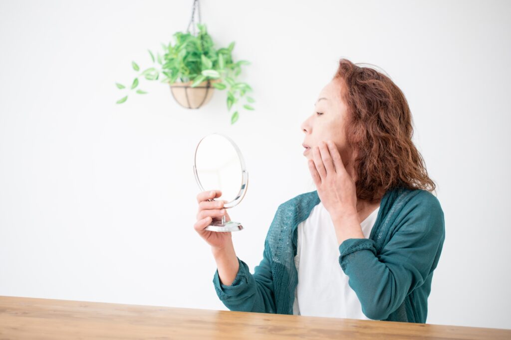  鏡を見る中高年の女性